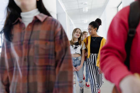 Young high school students walking in corridor at school, back to school concept.の写真素材