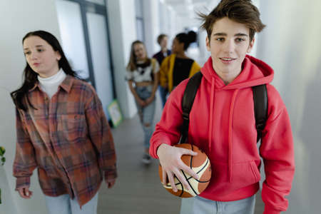 Young high school students walking in corridor at school, back to school concept.の写真素材