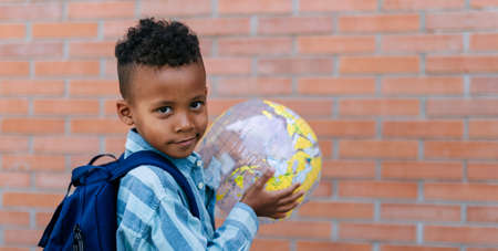 Multiracial boy playing outdoor with beach ball.の写真素材