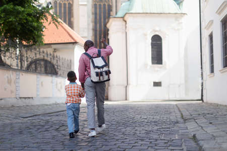 Multiracial father with his son travelling together, walking in old city centre.の写真素材