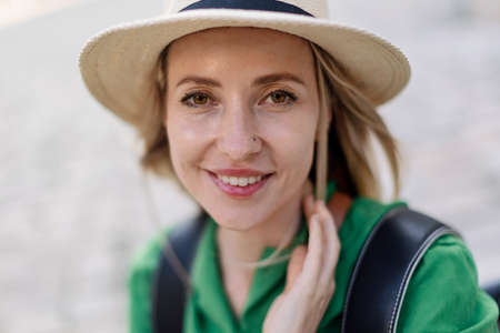 Portrait of young woman traveler, sitting, resting, smiling and looking at camera.の写真素材