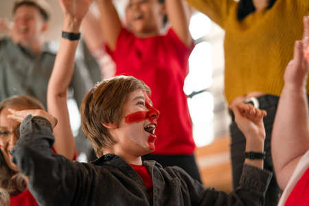 Excited football fans supproting English national team in live soccer match at stadium.の写真素材