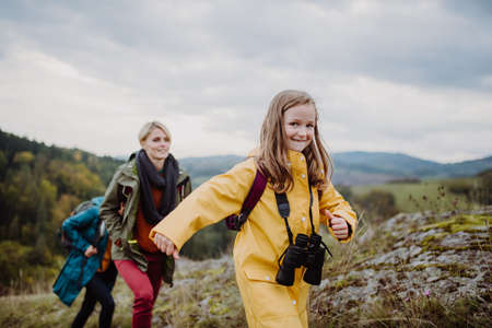 Small girl with mother and grandmother hiking outoors in nature.の写真素材