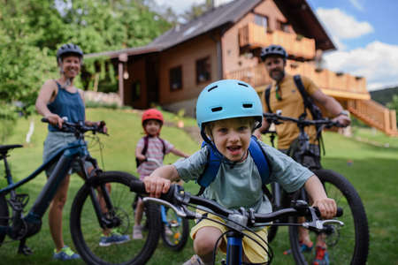 Young family with little children preaparing for bike ride, in front of house.