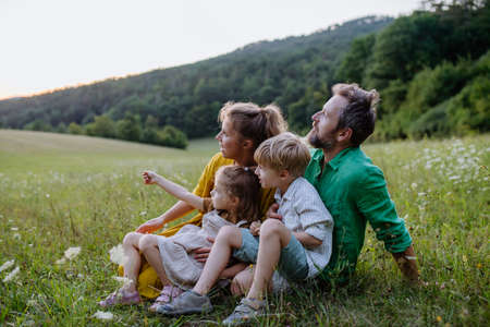 Happy young family spending time together outside in green nature.の写真素材