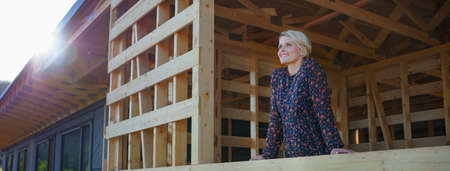 Young woman on site inside construction framing dreaming of her new home.の写真素材