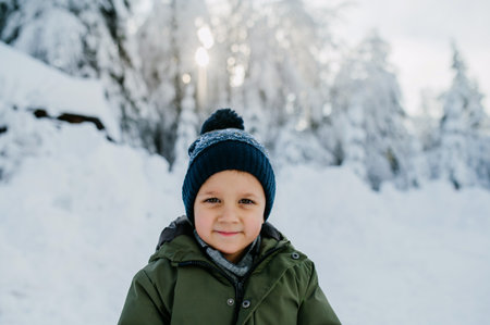 Winter portrait of little boy in warm clothes, outdoors during winter day.