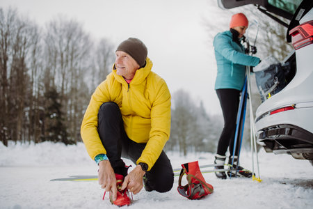Senior couple near car trunk preparing for winter skiing.の写真素材