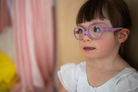 Little girl with down syndrome at ballet class in dance studio. Concept of integration and education of disabled children.の写真素材