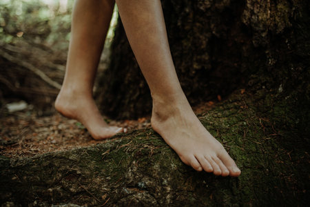 Close-up of barefoot legs walking in nature. Concept of healthy feet.の写真素材