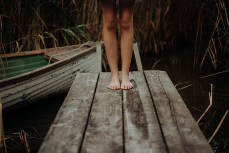 Close-up of barefoot legs standing on wooden pier. Concept of healthy feet.の写真素材