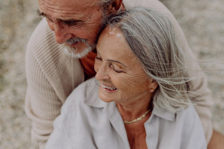 Senior couple relaxing and having romantic moment near the autumn sea.の写真素材