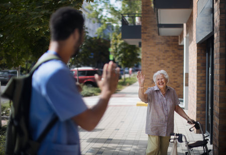 Caregiver saying goodbye his senior woman client at nursing home.の写真素材