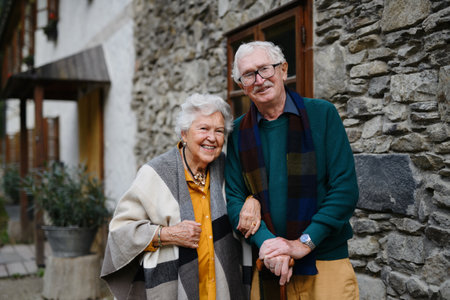 Happy senior couple posing near old countryside house.の写真素材