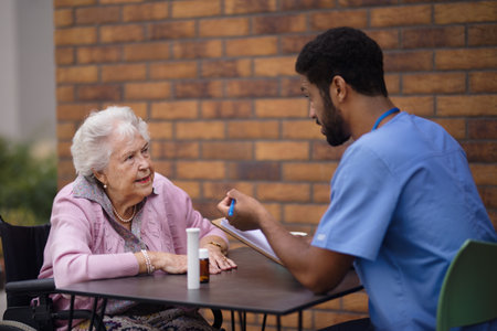 Caregiver explaning taking pills to senior woman.