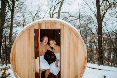 Senior couple enjoying together time in wooden sauna, relax, spa and healthy lifestlye concept.の写真素材