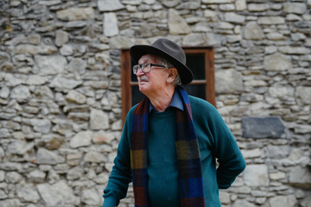Portrait of senior man with black hat leaning of his house.の写真素材