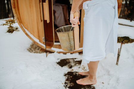 Low angle view of seniors entering in to outdoor hot tub with pail.の写真素材