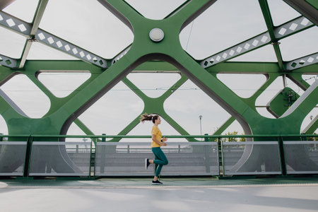 Young woman jogging at city bridge, healthy lifestyle and sport concept.の写真素材