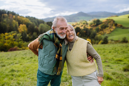 Happy senior couple walking in autumn meadow.の写真素材