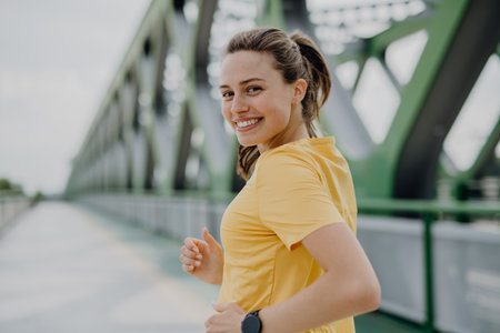 Young woman jogging at city bridge, healthy lifestyle and sport concept.の写真素材