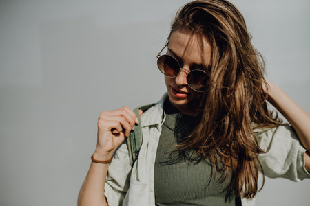 Portrait of happy young woman outdoor with backpack and sunglasses.の写真素材