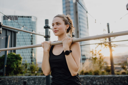 Young woman doing exercises at outdoor work-out city park.の写真素材