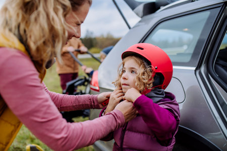 Young family with little children preparing for bicycle ride in nature, putting off bicycles from car racks. Healthy lifestyle concept.の写真素材