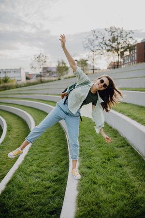 Happy young woman feeling free, posing during walking in city.