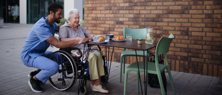 Caregiver having breakfast with his client at cafe.