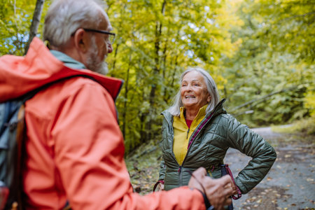 Happy senior couple hiking in autumn forest.の写真素材