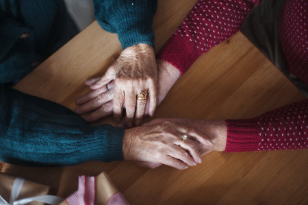 Top view of seniors couple hands holding each other, during Christmas.の写真素材