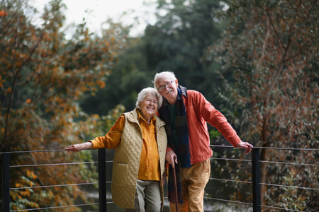 Happy senior couple at autumn walk near the lake, having break.の写真素材