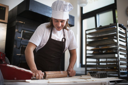 Young baker preparing pastries in bakery.