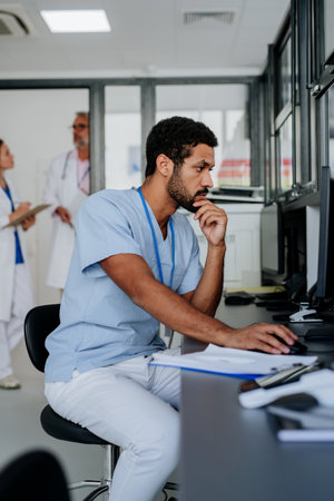 Portrait of young doctor working on computer in his office.の写真素材