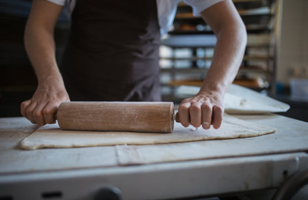 Close-up of young baker preparing pastries in bakery.の写真素材