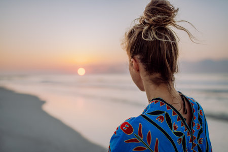 Rear view of young woman enjoying time at sea.の写真素材