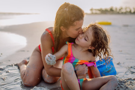 Mother with her little daughter enjoying time at sea.