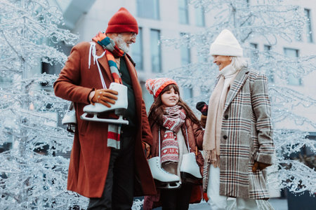 Seniors with their granddaughter in winter at outdoor ice skating rink.