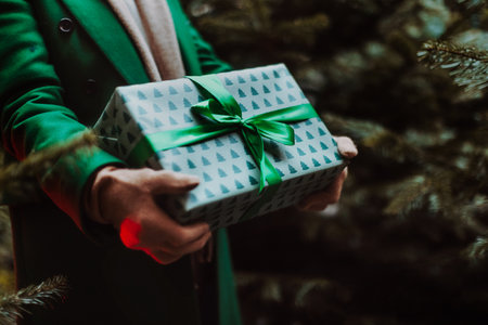 Close-up of woman holding gifts, outdoor at Christmas market.の写真素材
