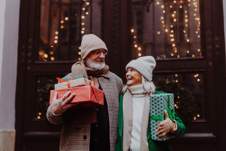 Happy senior couple enjoying christmas market, buying gifts.