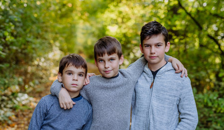 Portrait of three boys, brothers standing in forest.の写真素材