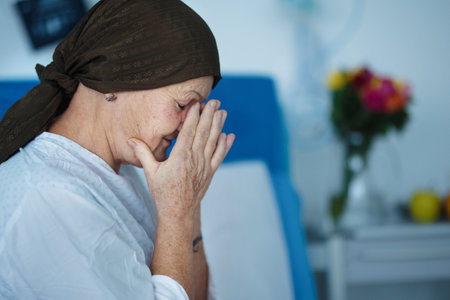 Senior woman sitting in hospital room after chemotherapy.の写真素材