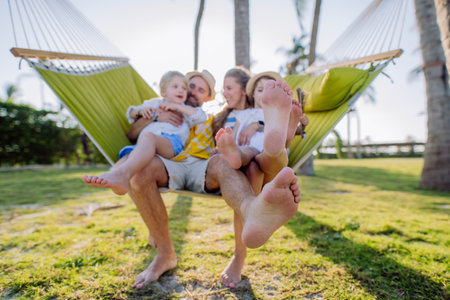 Young family with little kids enjoying their holiday in exotic country, lying in hammock.の写真素材