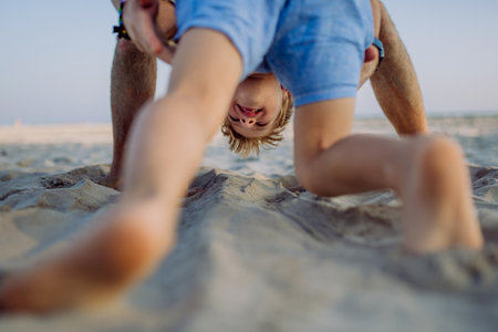 Father playing with his son, enjoying summer vacation, having fun.の写真素材