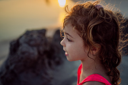 Portrait of little girl during playing on the beach, digging hole in sand.の写真素材