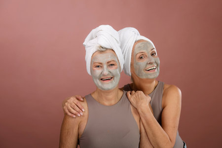 Portrait of happy senior friends with face-mask, selfcare and skin routine concept.