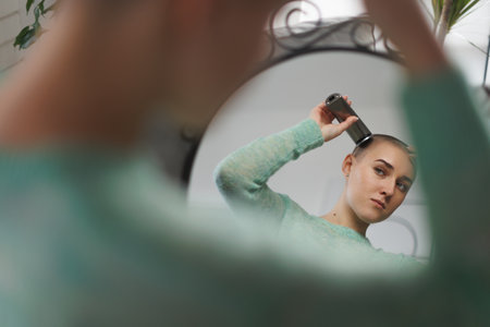 Young woman shaving her hair before chemotherapy.の写真素材