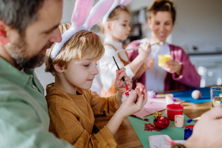 Happy family with little kids decorating easter eggs.の写真素材