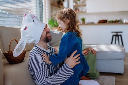 Little girl having fun with her dad, who is wearing Easter rabbit costume.の写真素材